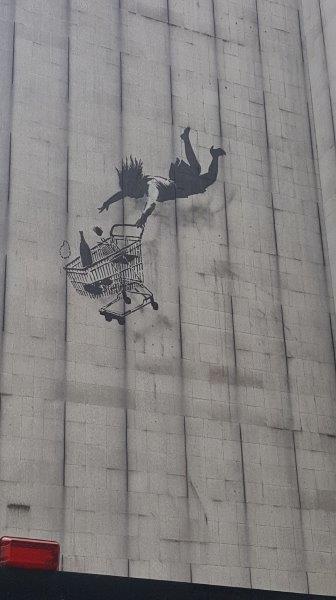 Woman holding a shopping cart grafitti in Mayfair, London