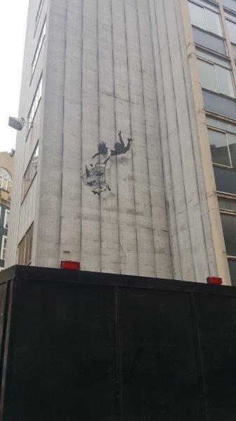 Woman holding a shopping cart grafitti in Mayfair, London