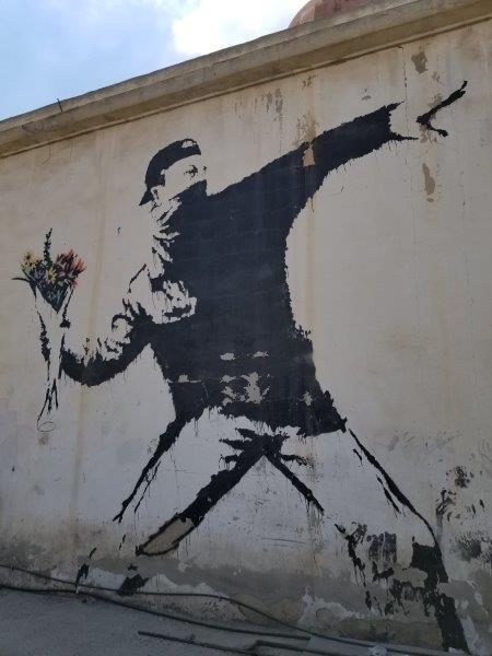 Masked Thug throwing flowers on a gas station in the West Bank