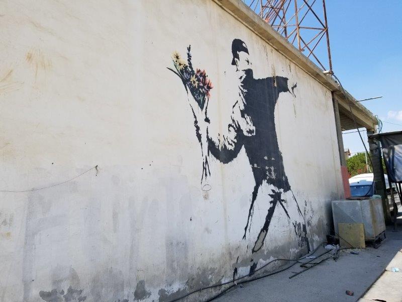 Masked Thug throwing flowers on a gas station in the West Bank