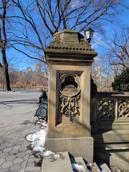 Pillars in Bethesda Terrace with representations of night with books with a candle for light