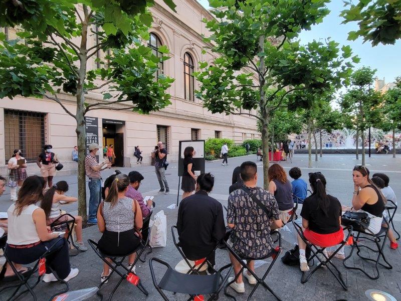 Drawing class outside the met with people sitting on chairs