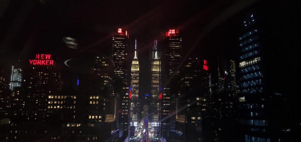 Reflection of Empire State Building with the New Yorker Hotel sign in NYC