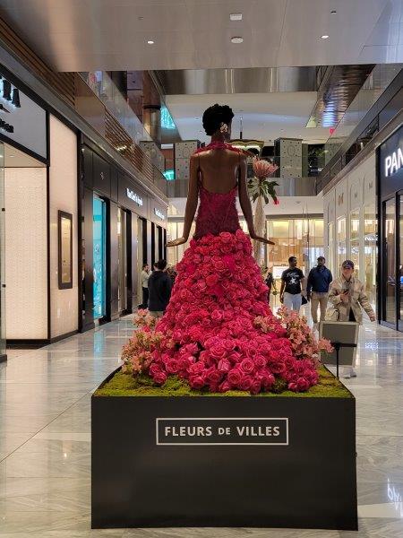 Back of Billie Holiday floral mannequin in an outfit made of greens and roses