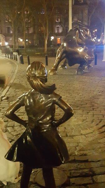 The Fearless Girl statue across Charging Bull in Bowling Green