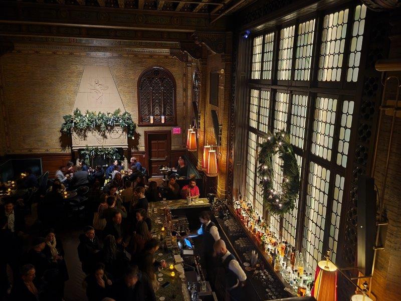 Looking Down at the expansive windowns behind the bar at Campbell Bar fom the upper level