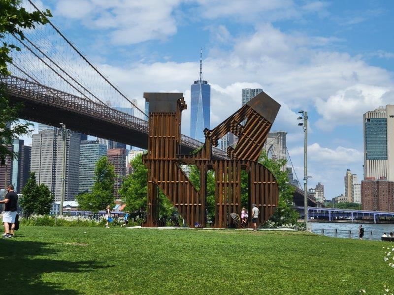 Brooklyn Bridge connecting Brooklyn to Manhattan. The LAND sculpture in DUMBO is in the foreground