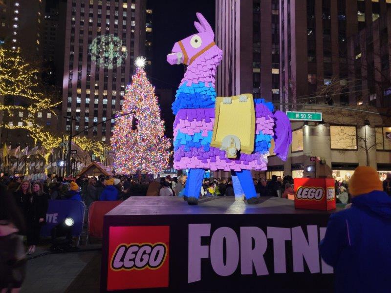 LEGO Supply Llama with a backdrop of Rockefeller Center Christmas Tree by night