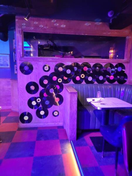 Records on a wall with retro seating 