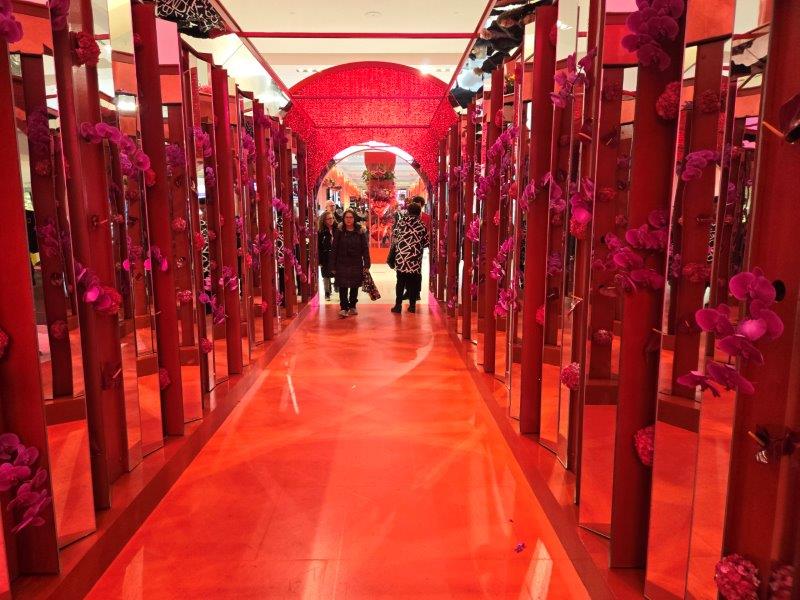 Red passage with flowers and mirrors on the side for visitors to walk through