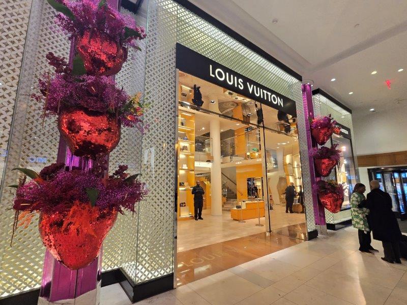 Louis Vuitton storefront framed by floral arrangements