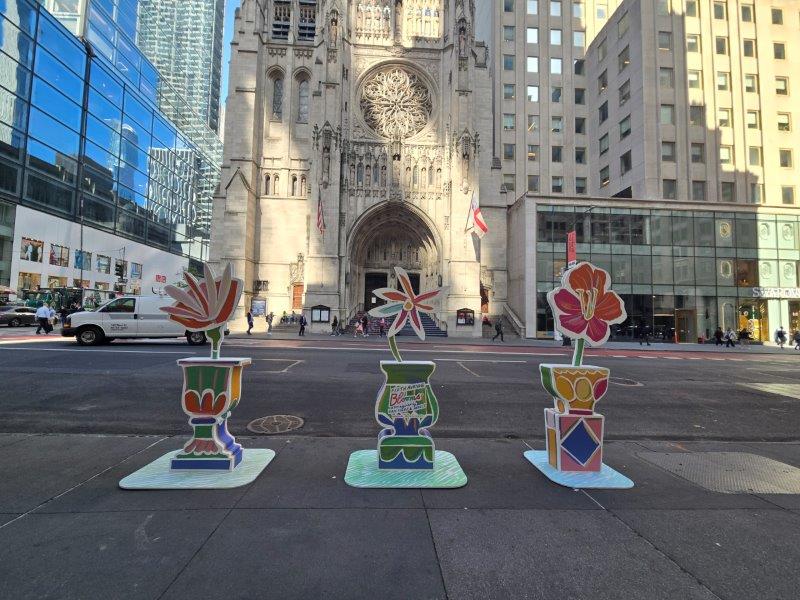 Three Flower installations with a single stylized flower on a pedestal 