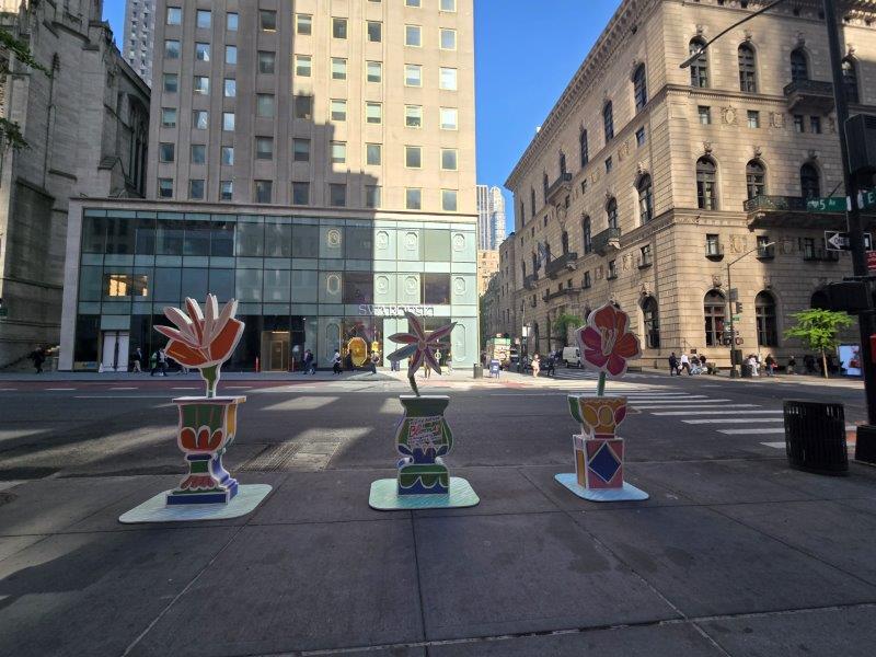 Three Flower installations with a single stylized flower on a pedestal 